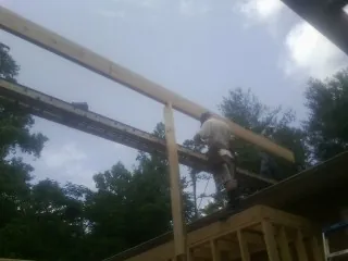 Carpenter setting a ridge beam over a new addition frame — Ice Dam Removal by Roofing Brothers in New Freedom