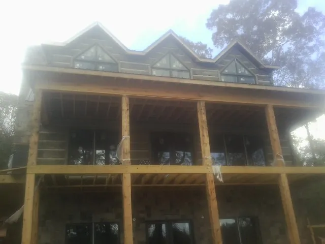 Dormers and porch framing on a large log home under construction — Roof Coating work by our crew in New Freedom