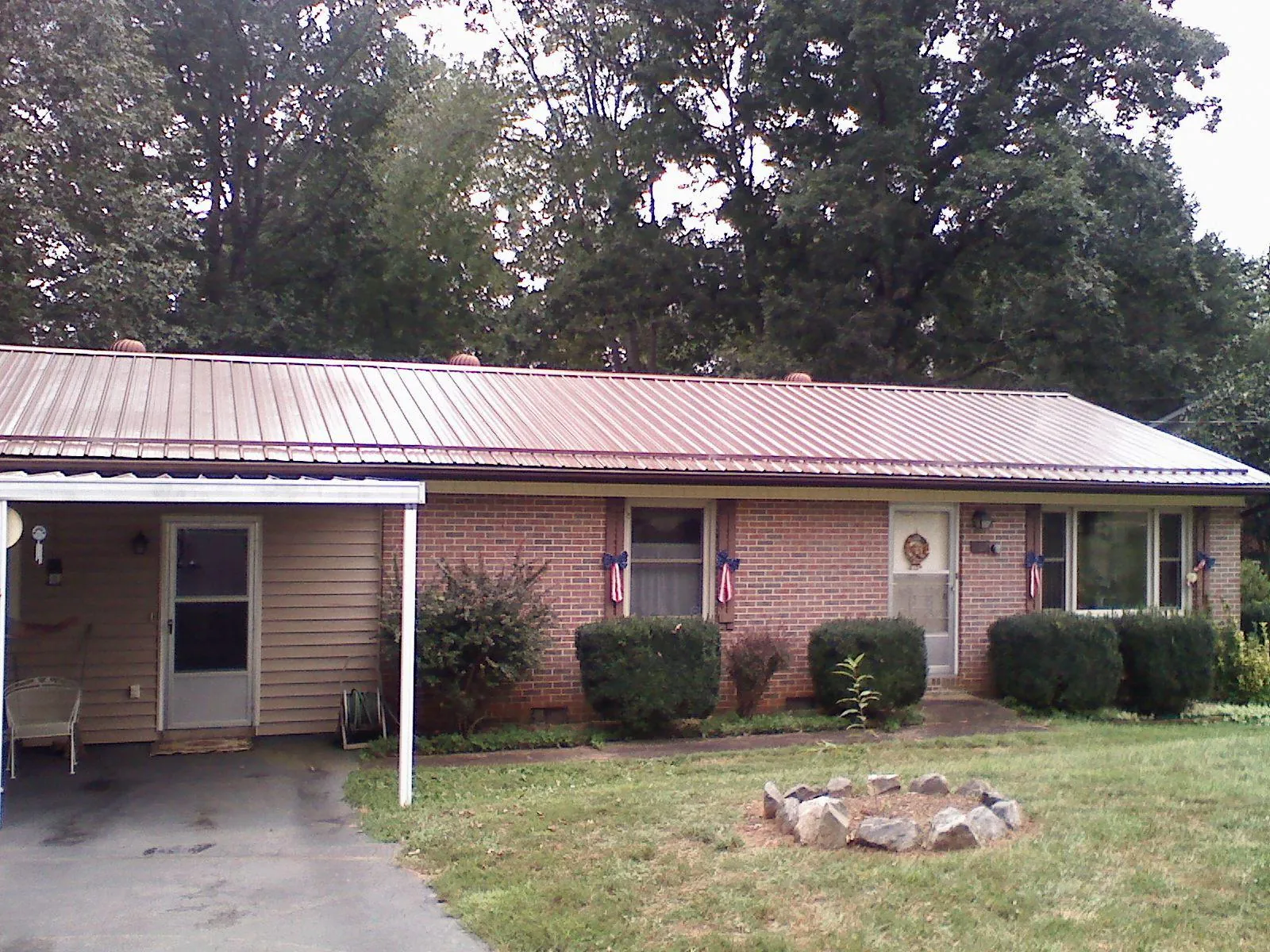 Bronze metal roof and carport on a brick ranch home — Roof Repair work by our crew in New Freedom